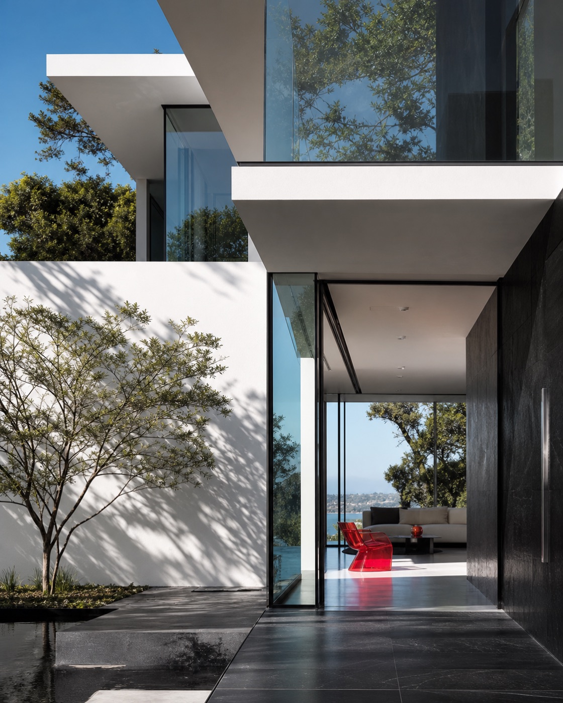 Contemporary luxury residence with white architecture, black stone and a red design detail